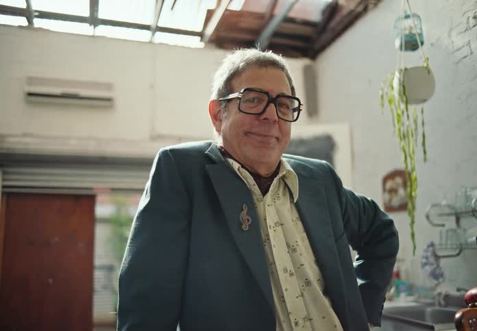 A man smirks while posing for a camera