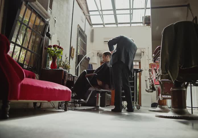 A barber is cutting a mans hair