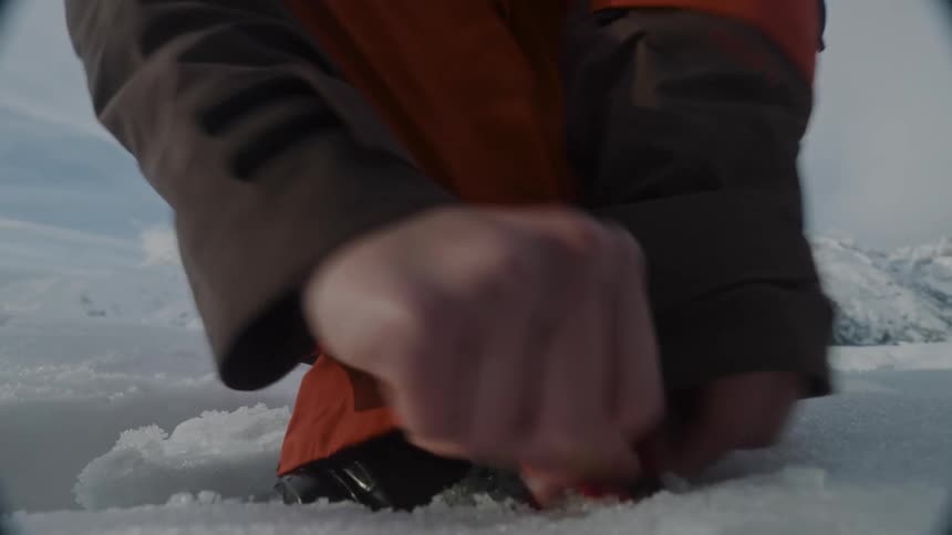 A person latches their ski boot