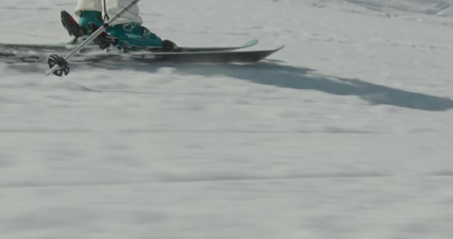 A skier moves quickly down a slope