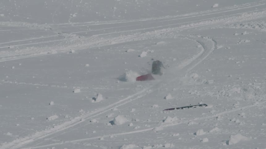 A skiers falling down in the middle of the mountain