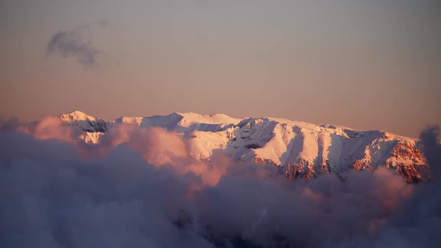 A region with many mountains covered in snow and a huge cloud leaving the environment mysterious