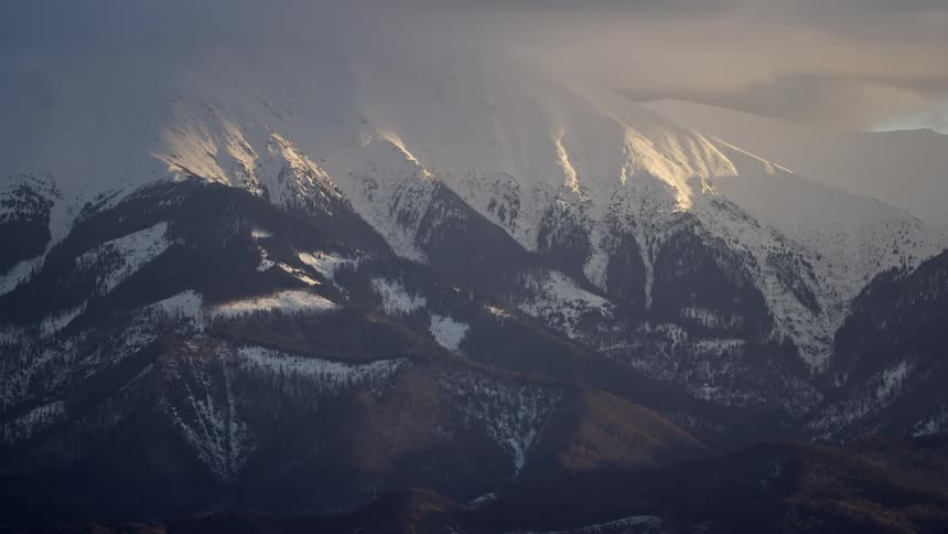 Mountain covered in snow and with sunrise reflection