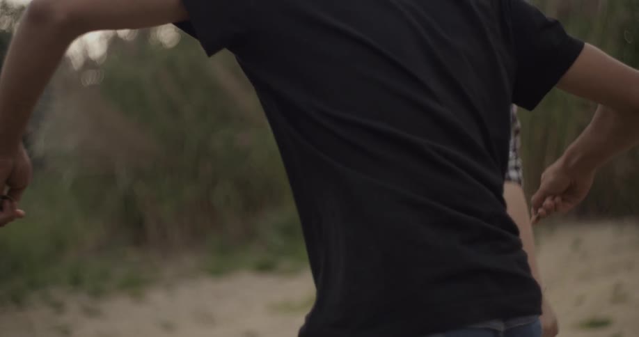 Man skips a rock while a girl stands and watches