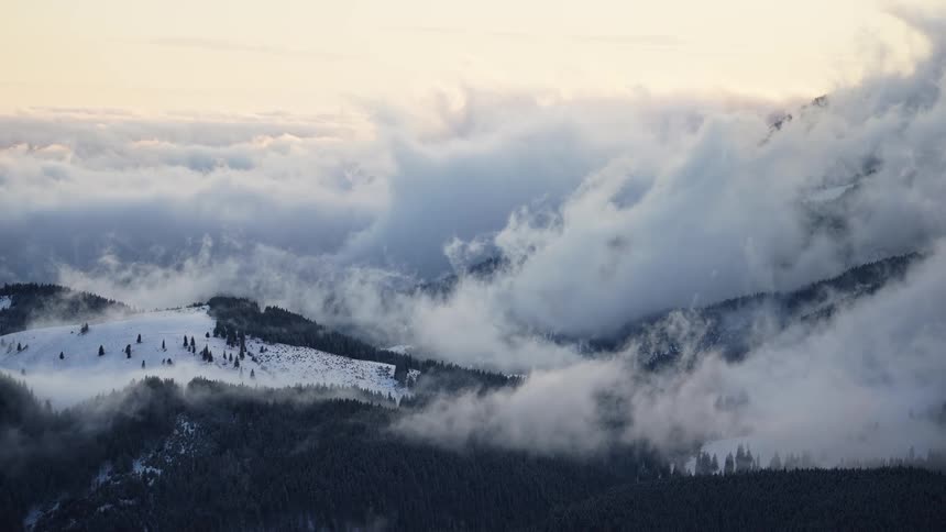 Some hills with lots of trees and a big cloud hanging over the place