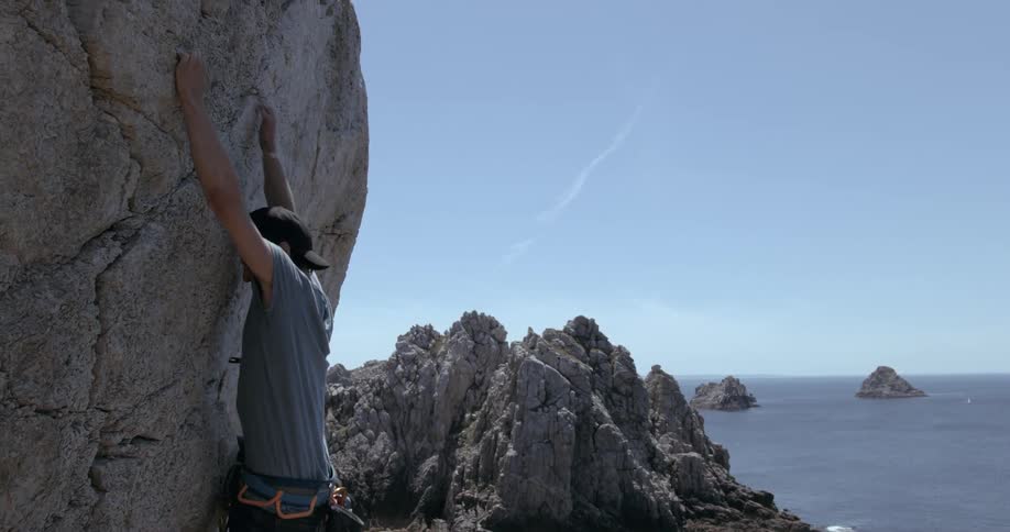 Man trying to climb a mountain wall and falling