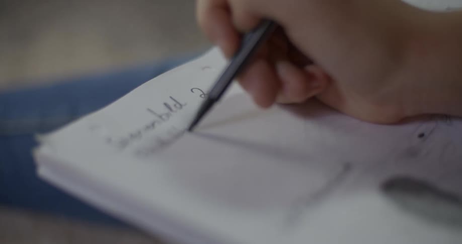 Someone is writing in a notebook