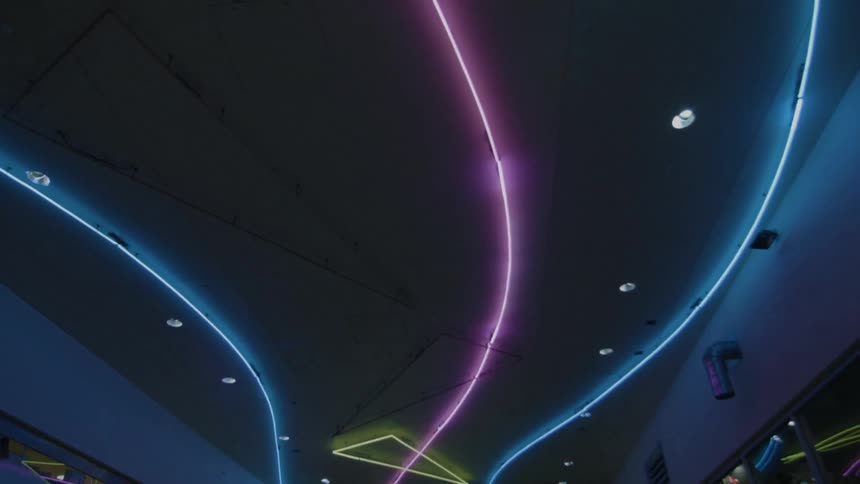 Neon lights on a ceiling are flashing off and on