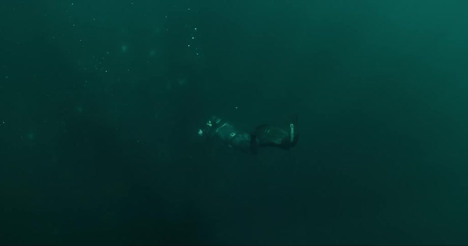 Person diving into the depths of the ocean