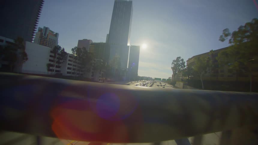 View of the handrail of an overpass with car traffic passing next to the cells in a metropolis