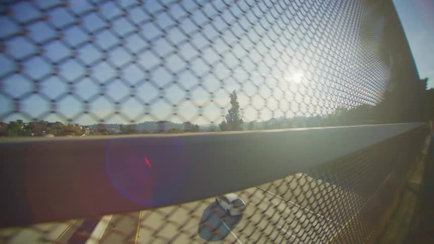Fence on a viaduct overlooking a highway with vehicle traffic