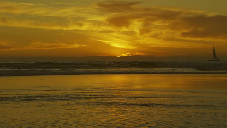 Sailboat on the horizon flat ocean and golden sky