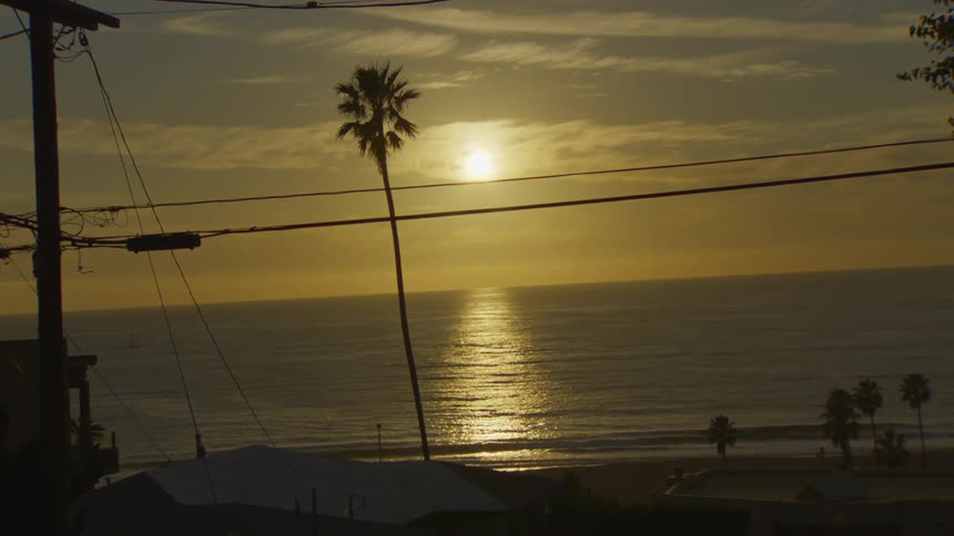 Landscape of a beach with the sun setting on the horizon