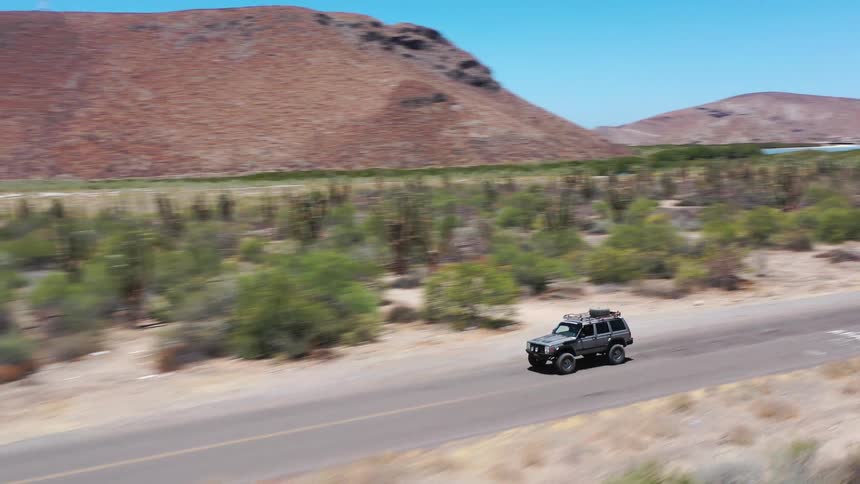 An atv drives down a desert road