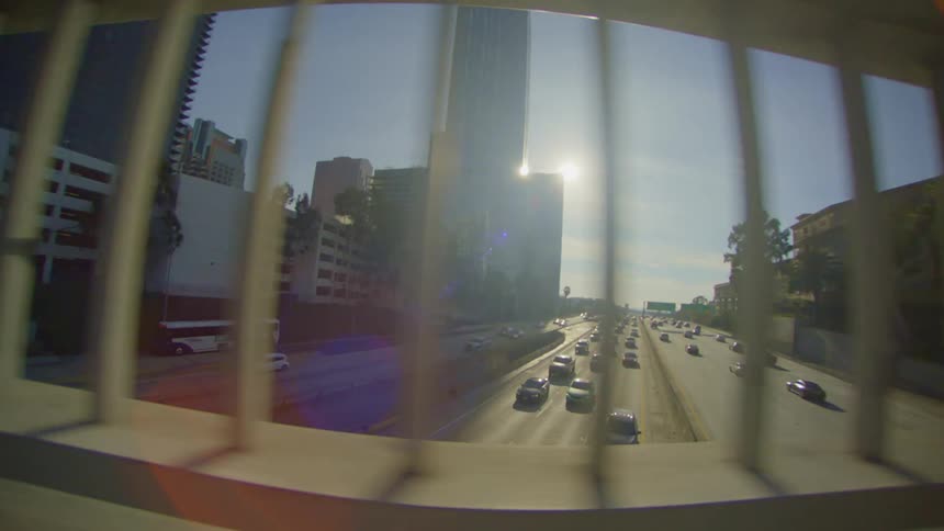 A highway with many cars and in front a street with a handrail