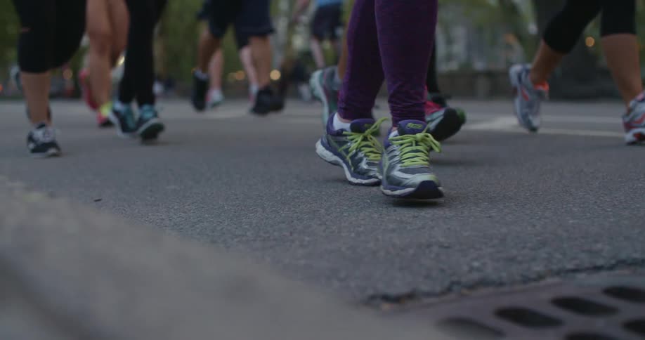 Runners are running along the blacktop as bicyclists ride by