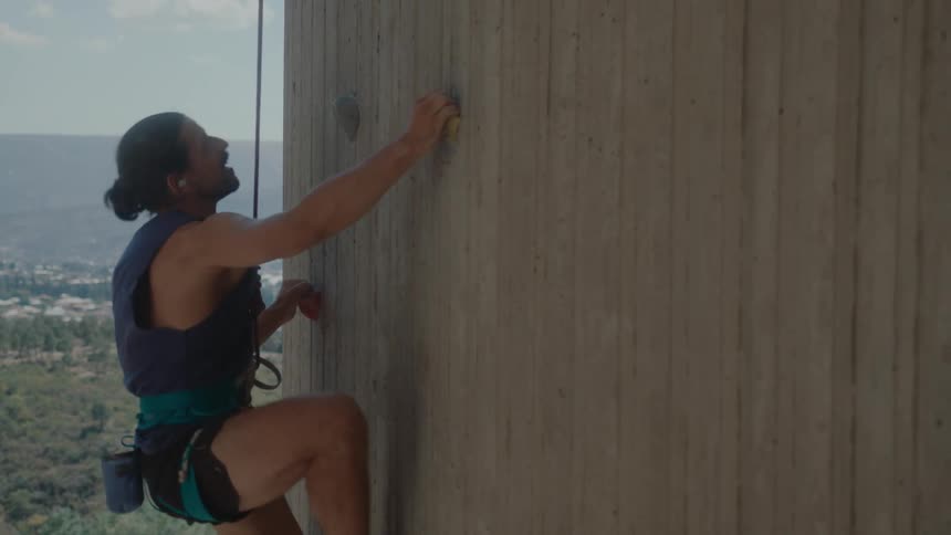 A man climbs a tall wooden structure