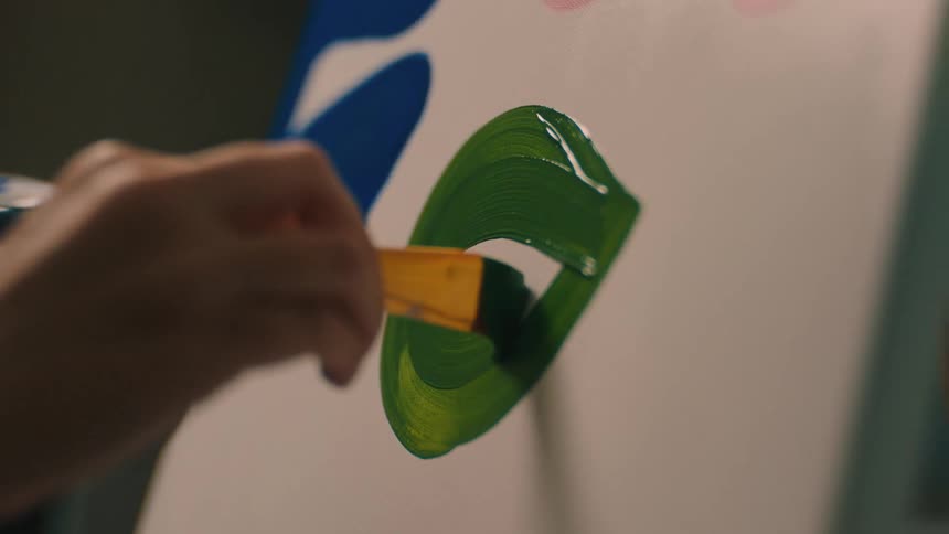A person paints on a canvas