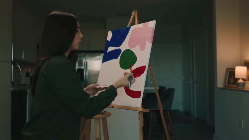 A slow motion video of a woman working on a painting
