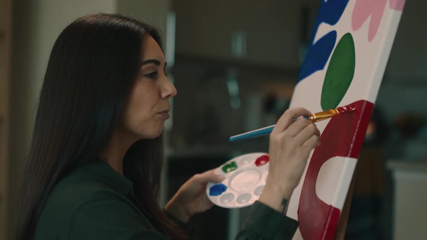 Portrait of a woman painting a canvas with a brush