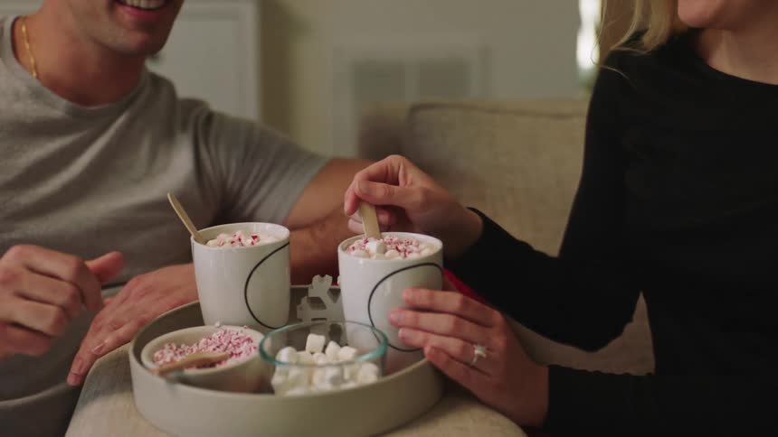 Two people having desserts sitting on a couch