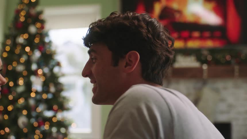 A man and a woman talk and smile in a living room