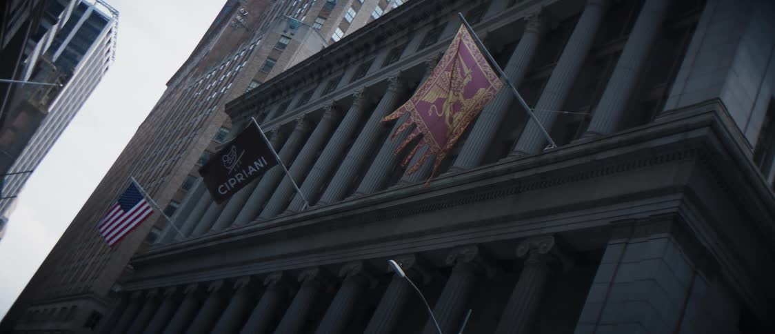 A corner building designed with columns and with hanging flags