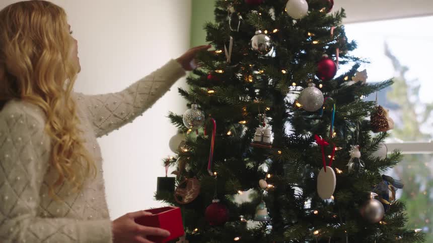 Woman adjusting her christmas tree