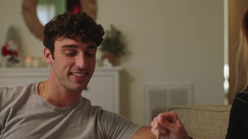 Couple sitting on the sofa with a cappuccino talking smiling