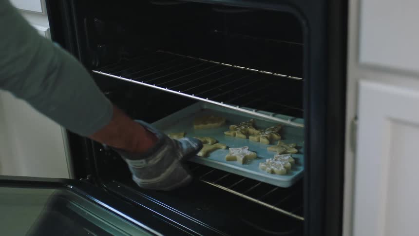 A person puts a pan of cookies in the oven
