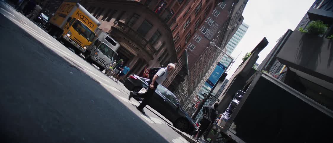 Vehicles and pedestrians cross city street at intersection