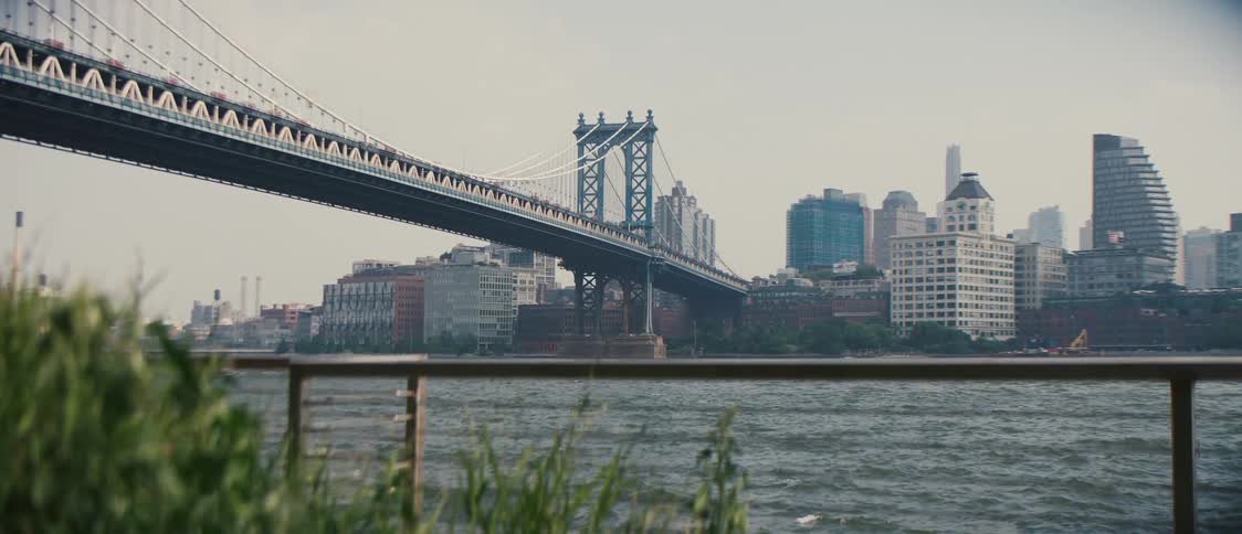 A long bridge crosses a river near a city