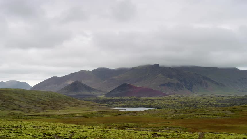 Panorama of a mountain range with a flowing river and a sky passing in timelapse