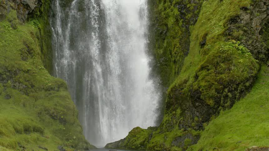 A powerful waterfall drops into a crevice