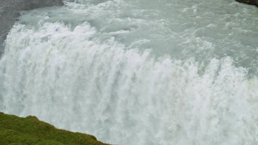 A view of a large waterfall outdoors on a sunny day