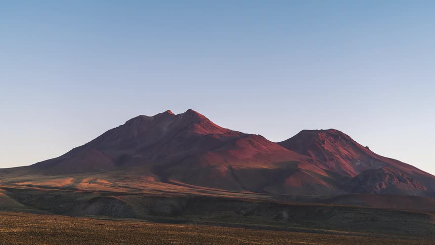 Mountain range and peaks with the sky transitioning from dusk to dawn in timelapse