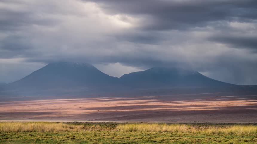 Clouds move over mountains and a desert