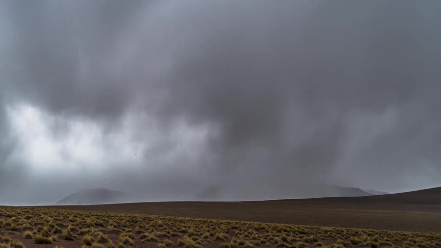 Storm with strong clouds in timelapse passing over hills and mountains
