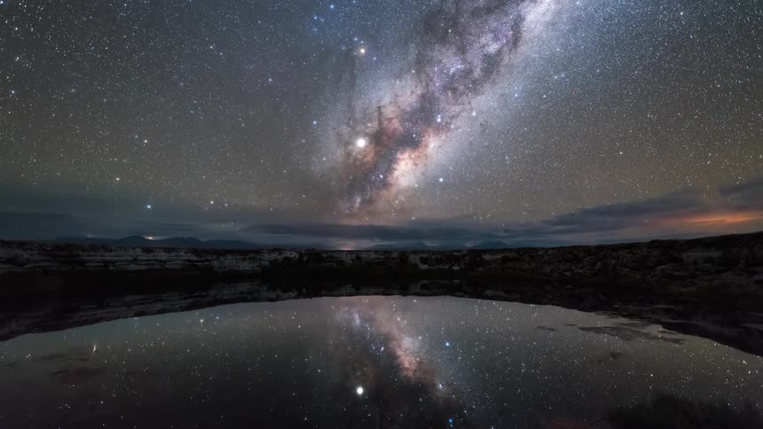 Nebula and stars reflecting over a lake at night in timelapse