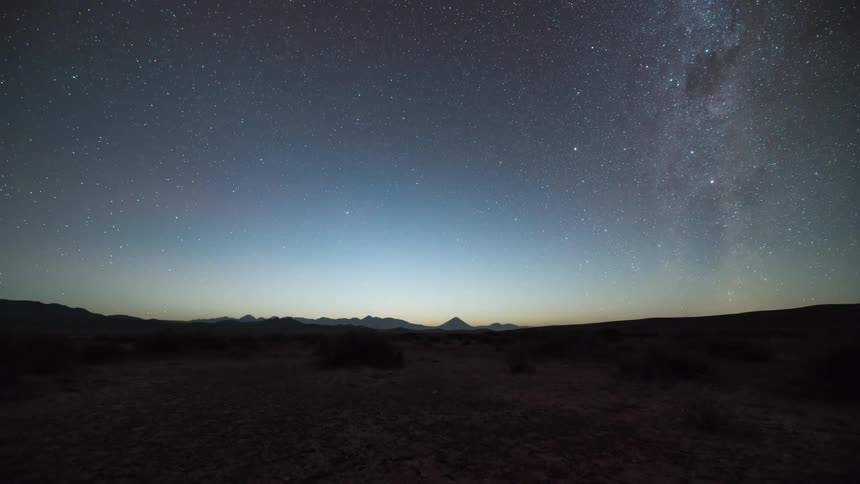 Landscape of the starry sky transitioning into dawn in timelapse