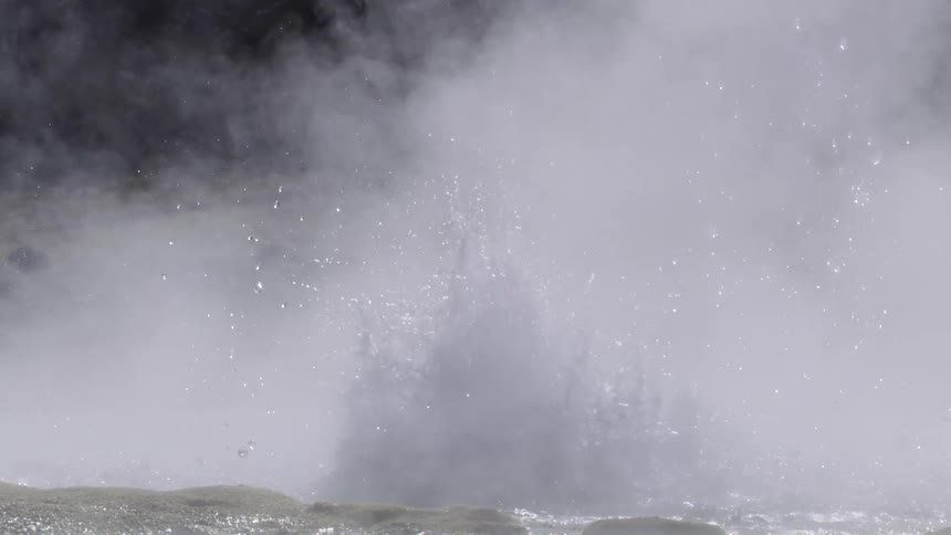 Hot water with smoke being splashed from a rock