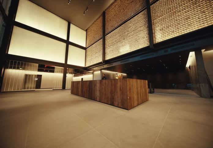 A man sits at a desk in a lobby