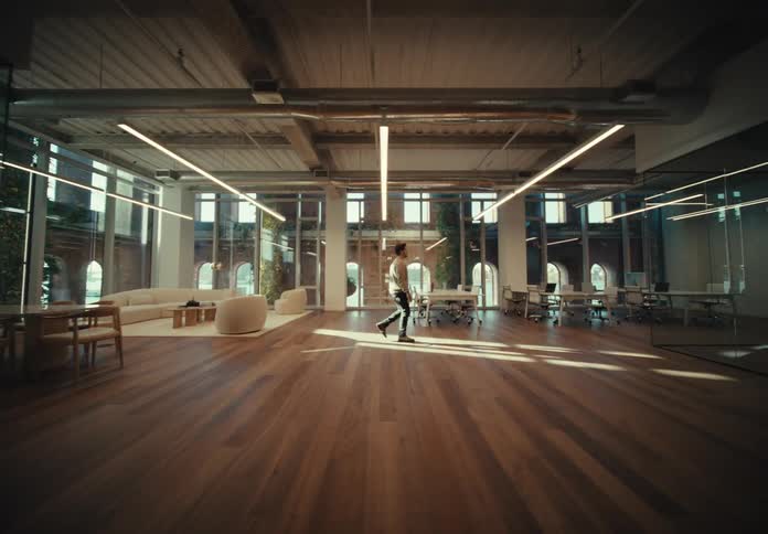 Man with a shirt and black pants walks in the spacious office