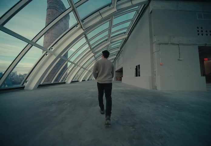 A man walks through a rooftop atrium in a city