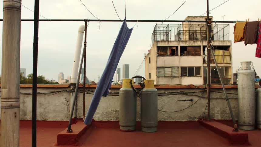 A blanket hangs out to dry on the roof of a building