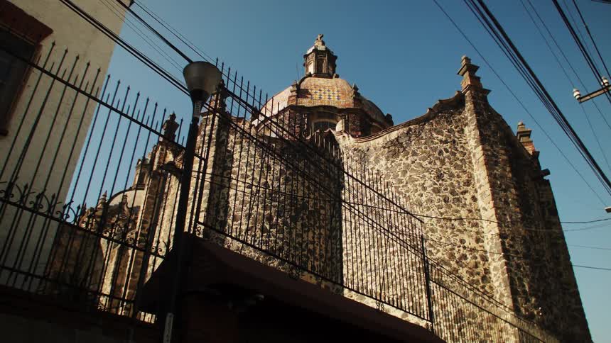 A stone cathedral with a dome and towers in a neighborhood