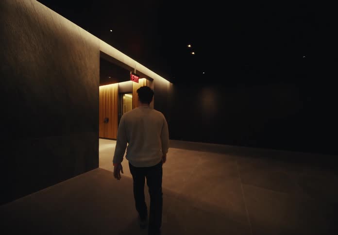Man entering a building lobby and heading towards an elevator