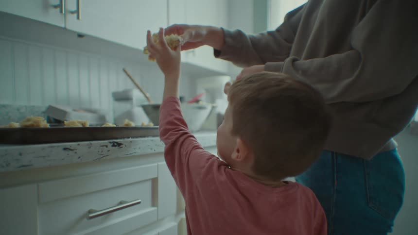 Mother and son puts food in a tray in the kitchen