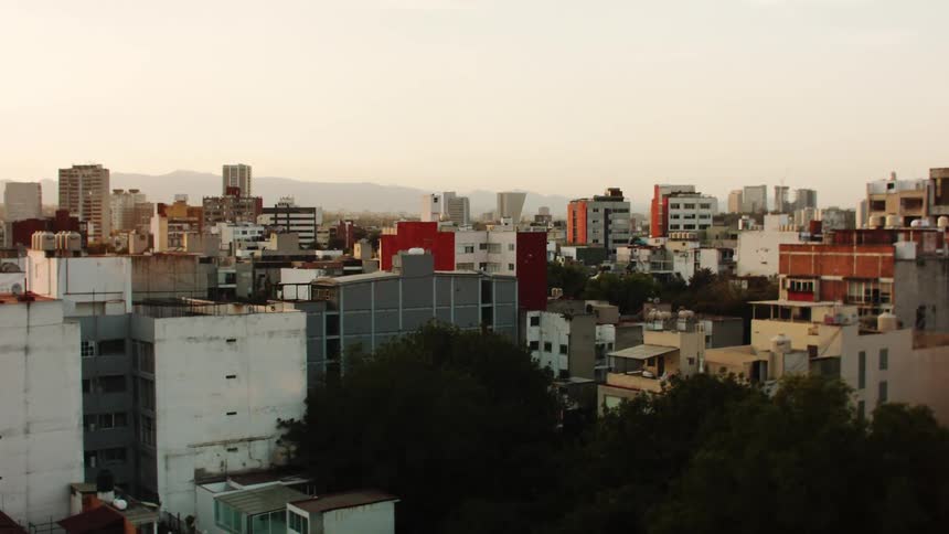 Panorama of a metropolitan city with buildings and the silhouette of a mountain in the background