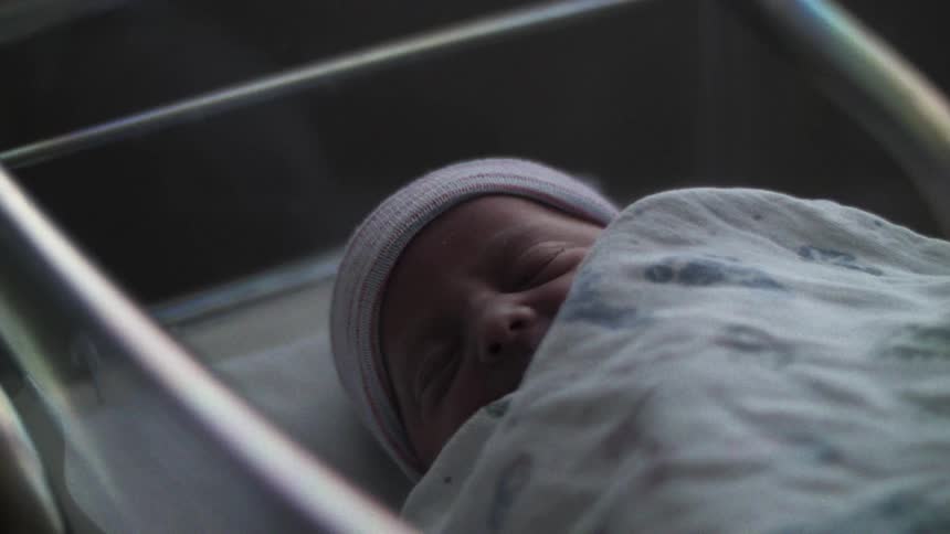 Portrait of a newborn baby in a crib